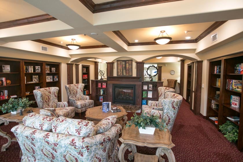 The library at Providence Meadows with shelves of books and comfortable seating
