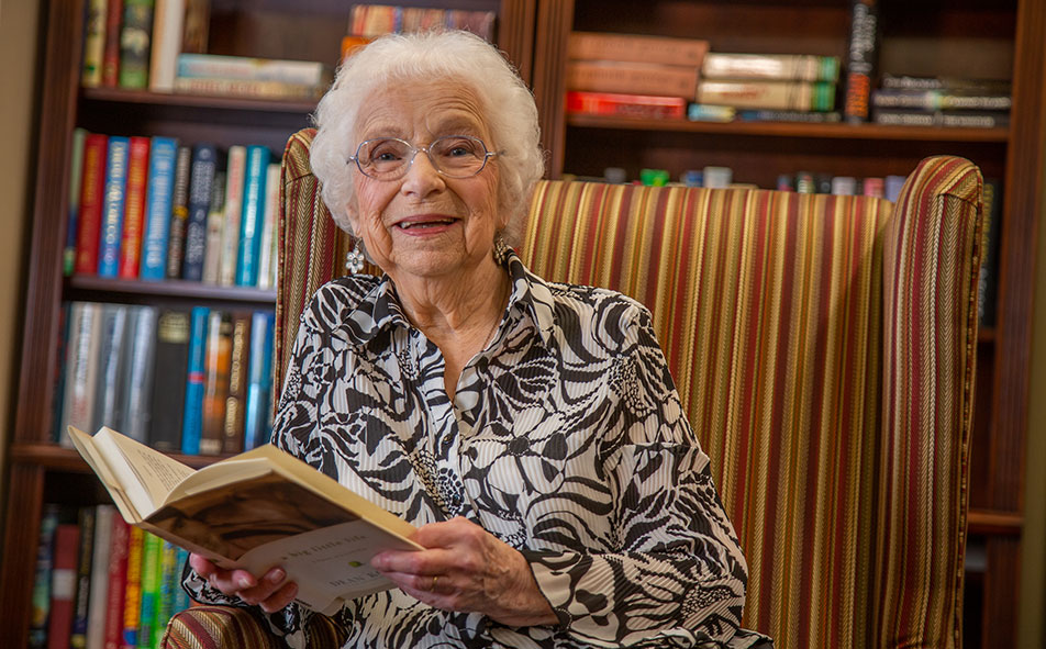 The library at Providence Meadows with shelves of books and comfortable seating